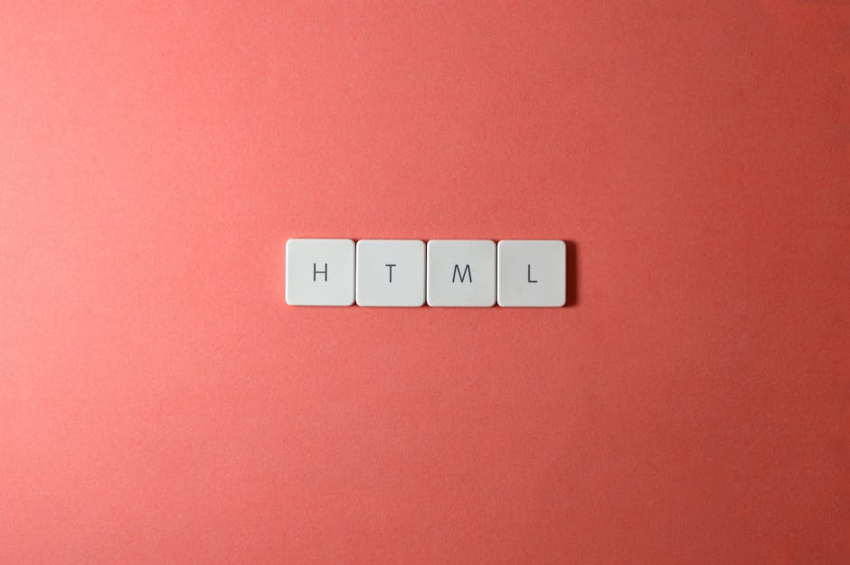 Close-up of four white square tiles with black letters spelling 'HTML' arranged in a horizontal line on a pink textured surface, with soft lighting highlighting the clean, smooth surface of the tiles.